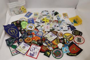 A LARGE COLLECTION OF CLOTH AND PIN BADGES TO INCLUDE GIRL GUIDES, BEAVERS, HOLIDAY DESTINATIONS,