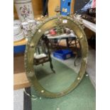 A LARGE BRASS FRAMED ARTS AND CRAFTS OVAL MIRROR