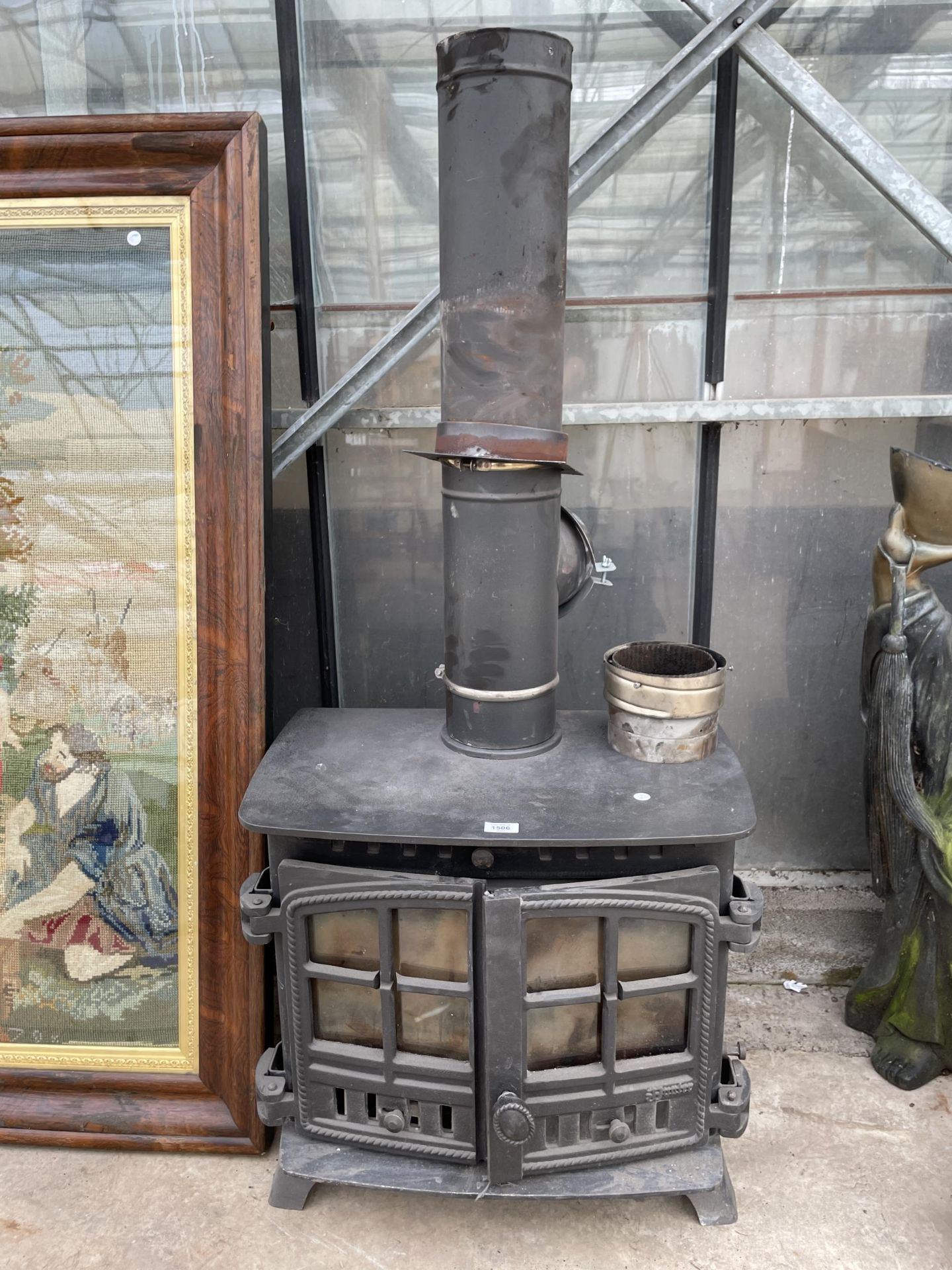 A CAST IRON LOG BURNER WITH FLU PIPE AND BRACKETS