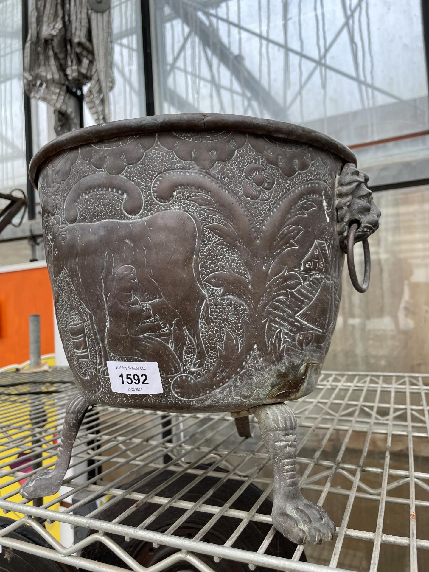 A VINTAGE ORNATE AND DECORATIVE COPPER PLANTER WITH TWIN LION HEAD HANDLES AND TRIPOD FEET