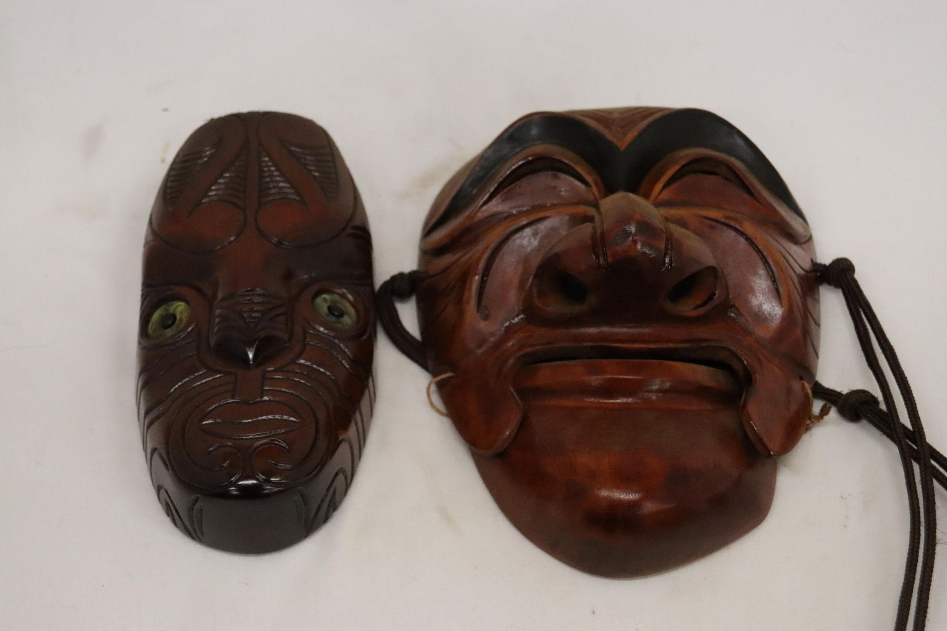 TWO WALL MASKS TO INCLUDE A JAPANESE ONE WITH MARKS TO INNER AND A NEW ZEALAND 'KORURU', 'RURU' IS