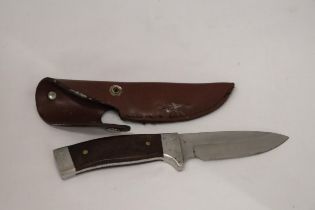 A HUNTING KNIFE IN A LEATHER SHEATH