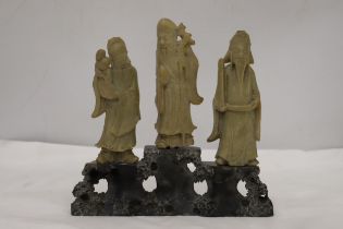 AN ORIENTAL CARVING OF THREE ELDERS ON A PLINTH, HEIGHT 21CM, WIDTH 22CM