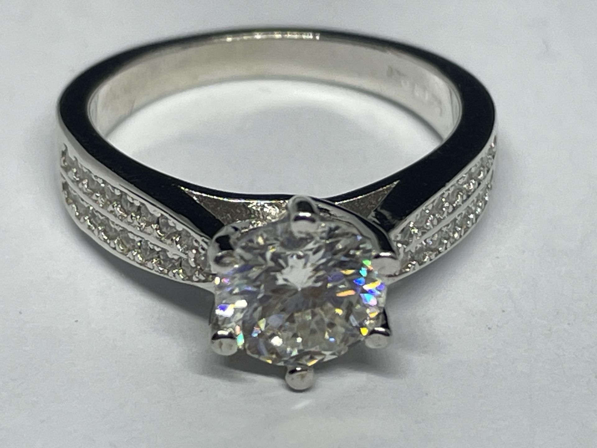 A MARKED 9K RING SET WITH A 1 CARAT OF MOISSANITE AS A SOLITAIRE AND CHIPS TO SHOULDERS SIZE I