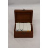 A WOODEN BOX CONTAINING A SET OF BONE DOMINOES