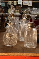 FOUR CUT GLASS DECANTERS ONE WITH A WHISKEY DECANTER LABEL