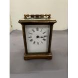 A VINTAGE BRASS CARRIAGE CLOCK WITH BEVELLED GLASS REVEALING THE INNER WORKINGS