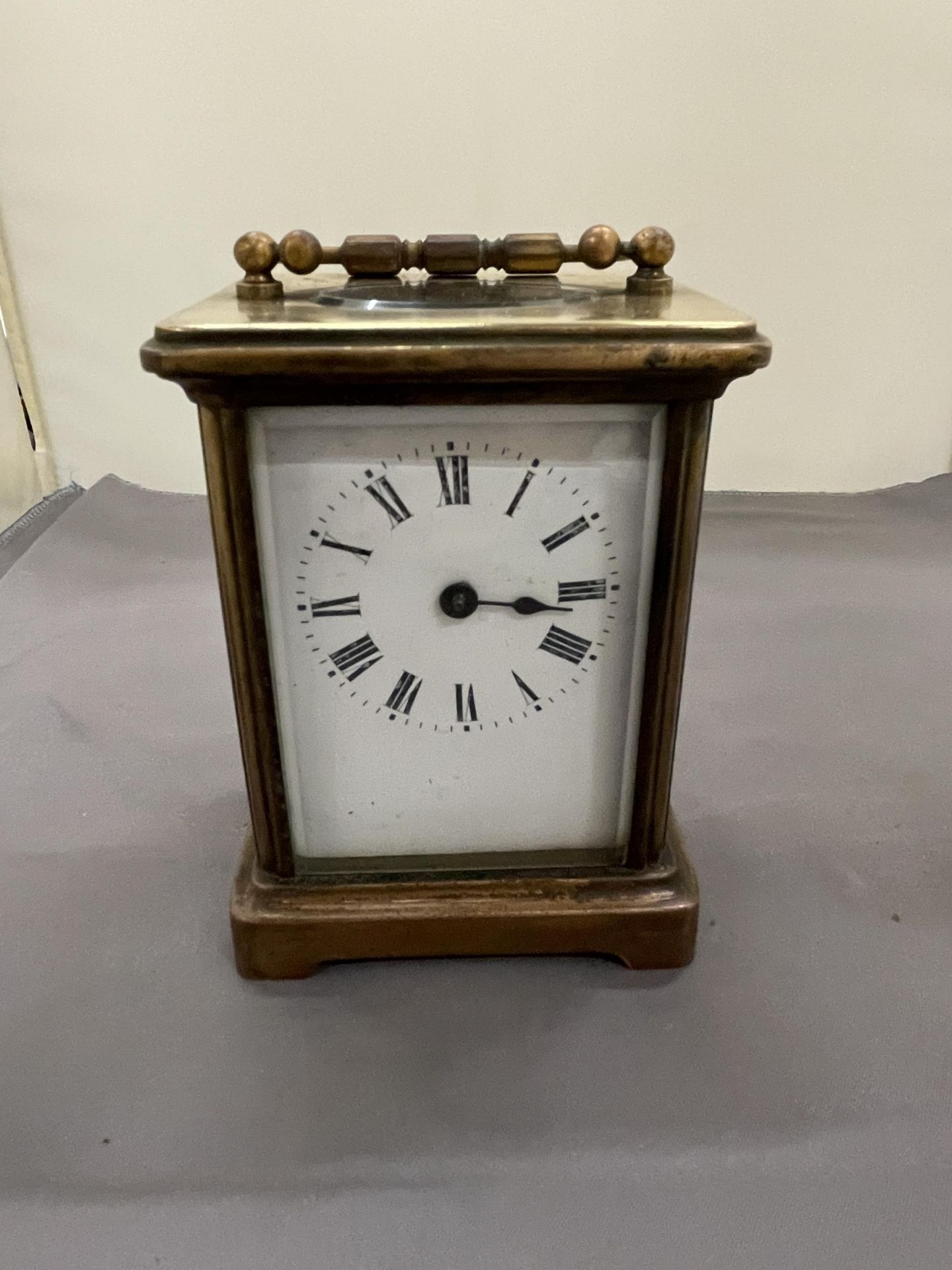 A VINTAGE BRASS CARRIAGE CLOCK WITH BEVELLED GLASS REVEALING THE INNER WORKINGS