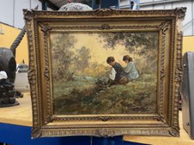 A GILT FRAMED OIL ON BOARD OF TWO CHILDREN BY A RIVER SIGNED 29.5CM X 23CM