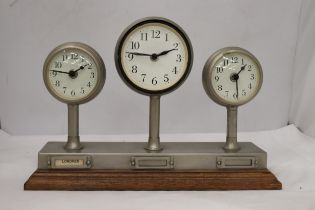 A CLOCKS OF THE WORLD MANTLE CLOCK ON A WOODEN STAND, HEIGHT 24CM, LENGTH 36CM