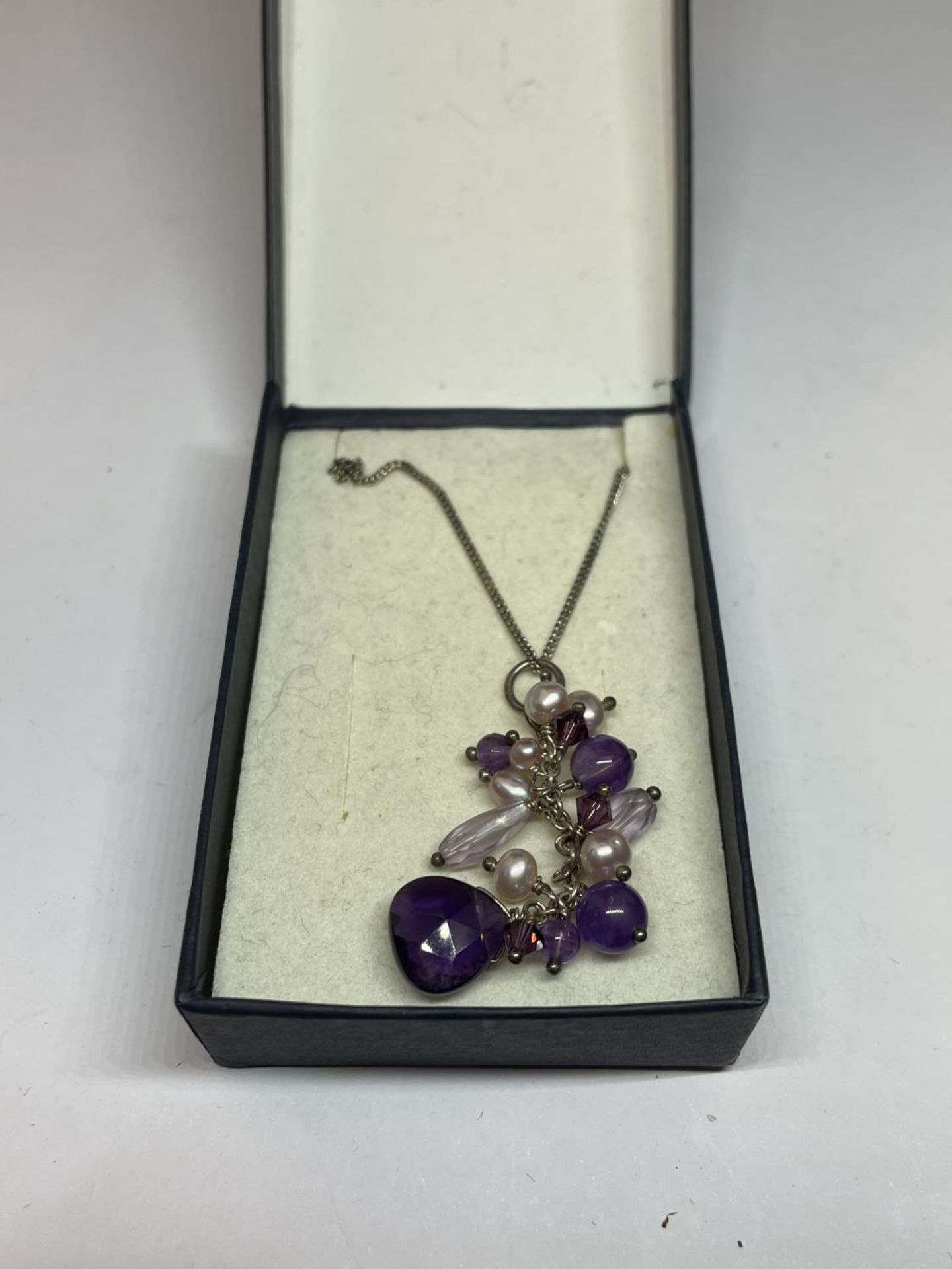A SILVER AND AMETHYST NECKLACE IN A PRESENTATION BOX