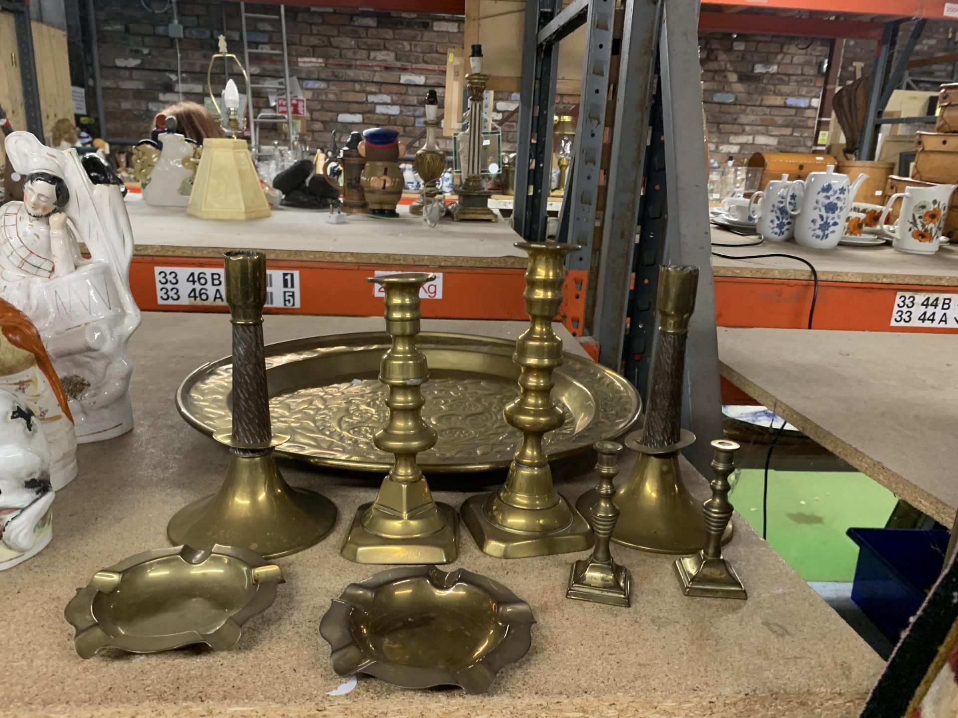 A LARGE VINTAGE BRASS WALL CHARGER, DIAMETER 45CM, SIX CANDLESTICKS AND TWO ASHTAYS