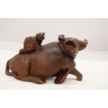 AN ORIENTAL WOODEN CARVED WATER BUFFALO WITH CHILD RIDER, A/F TO LEG, HEIGHT 12CM, LENGTH 22CM