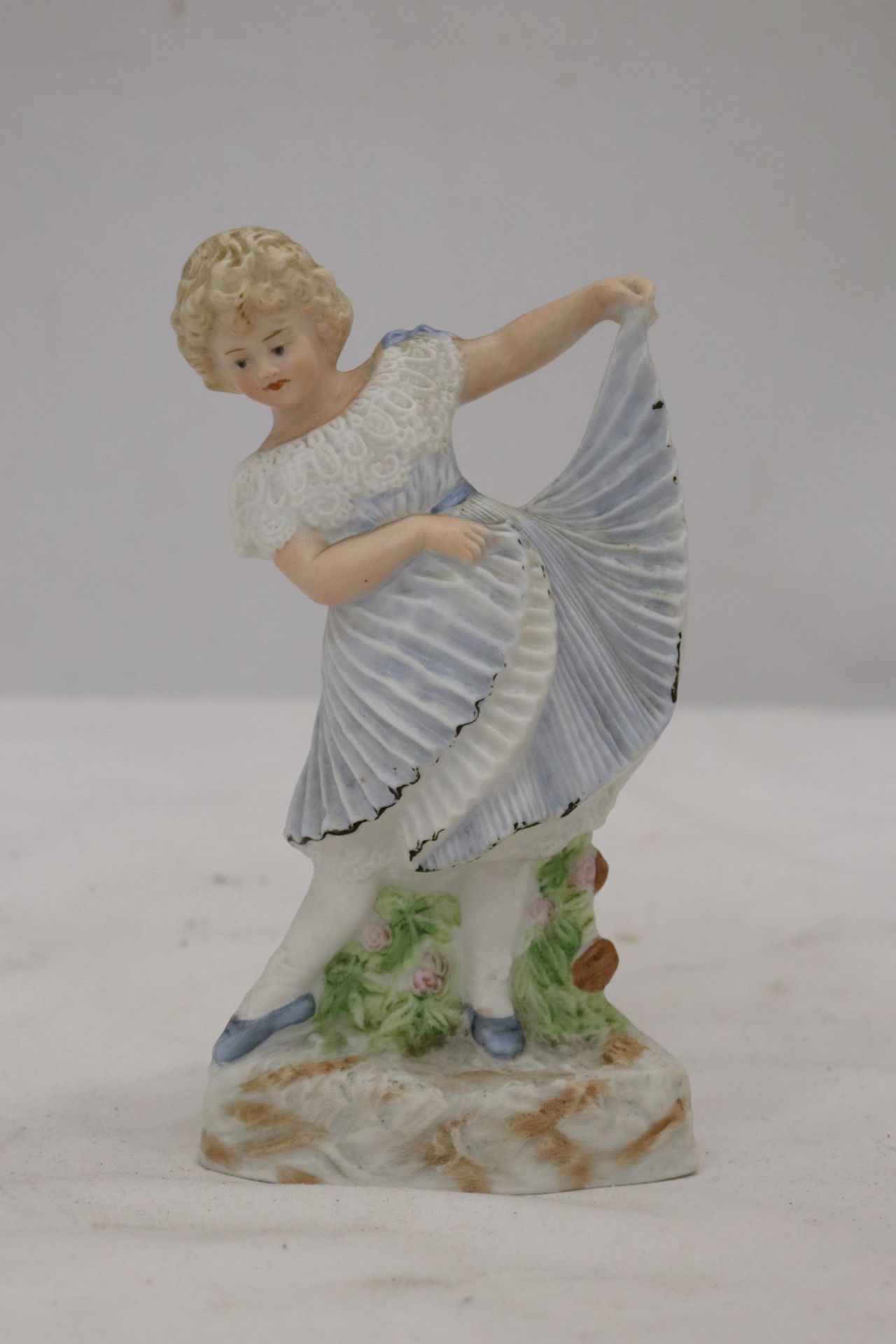 A BISQUE FIGURE OF A YOUNG LADY, MARKED TO THE BASE