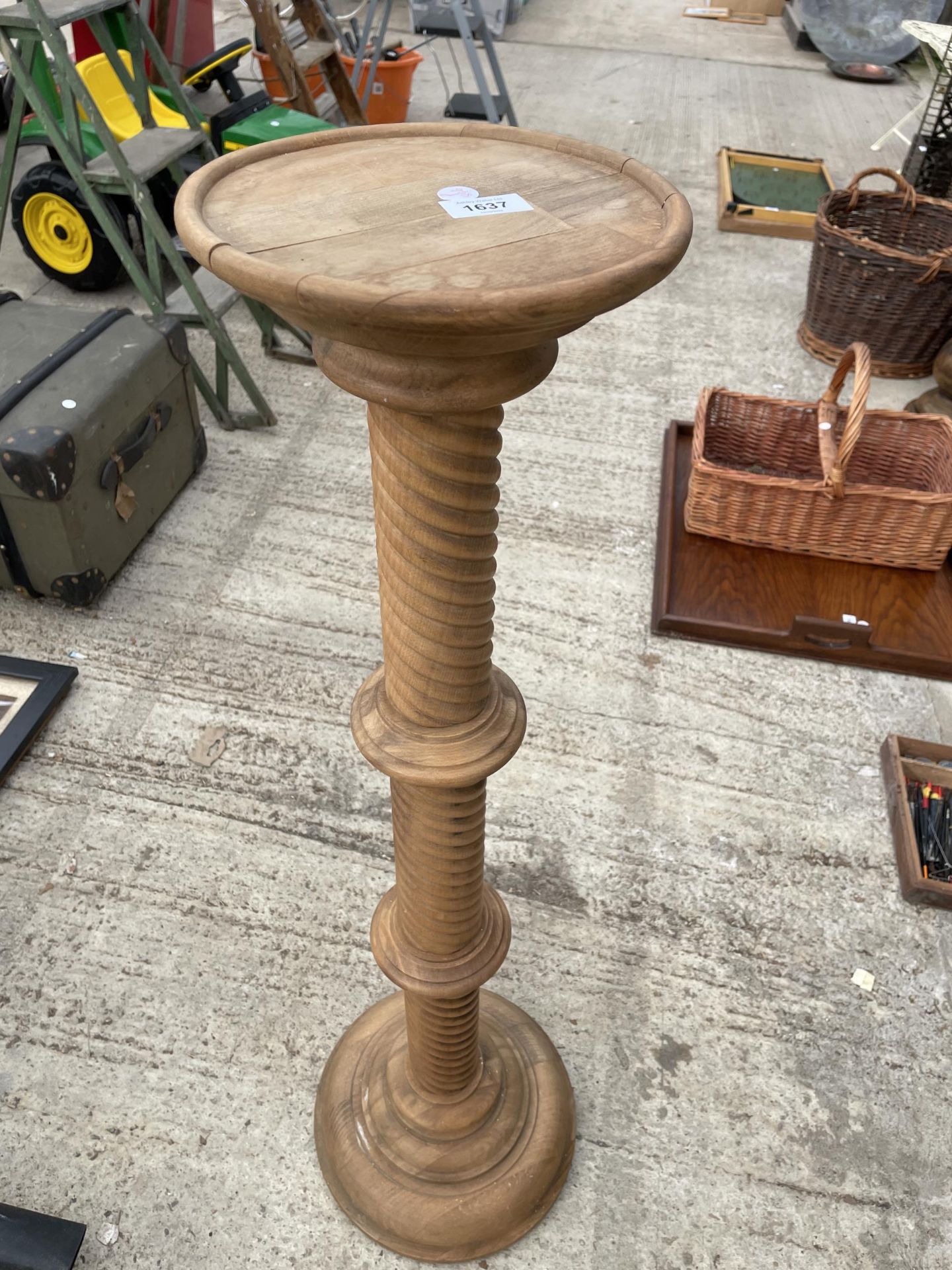 A WOODEN PLANT STAND WITH TWISTED PEDESTAL BASE