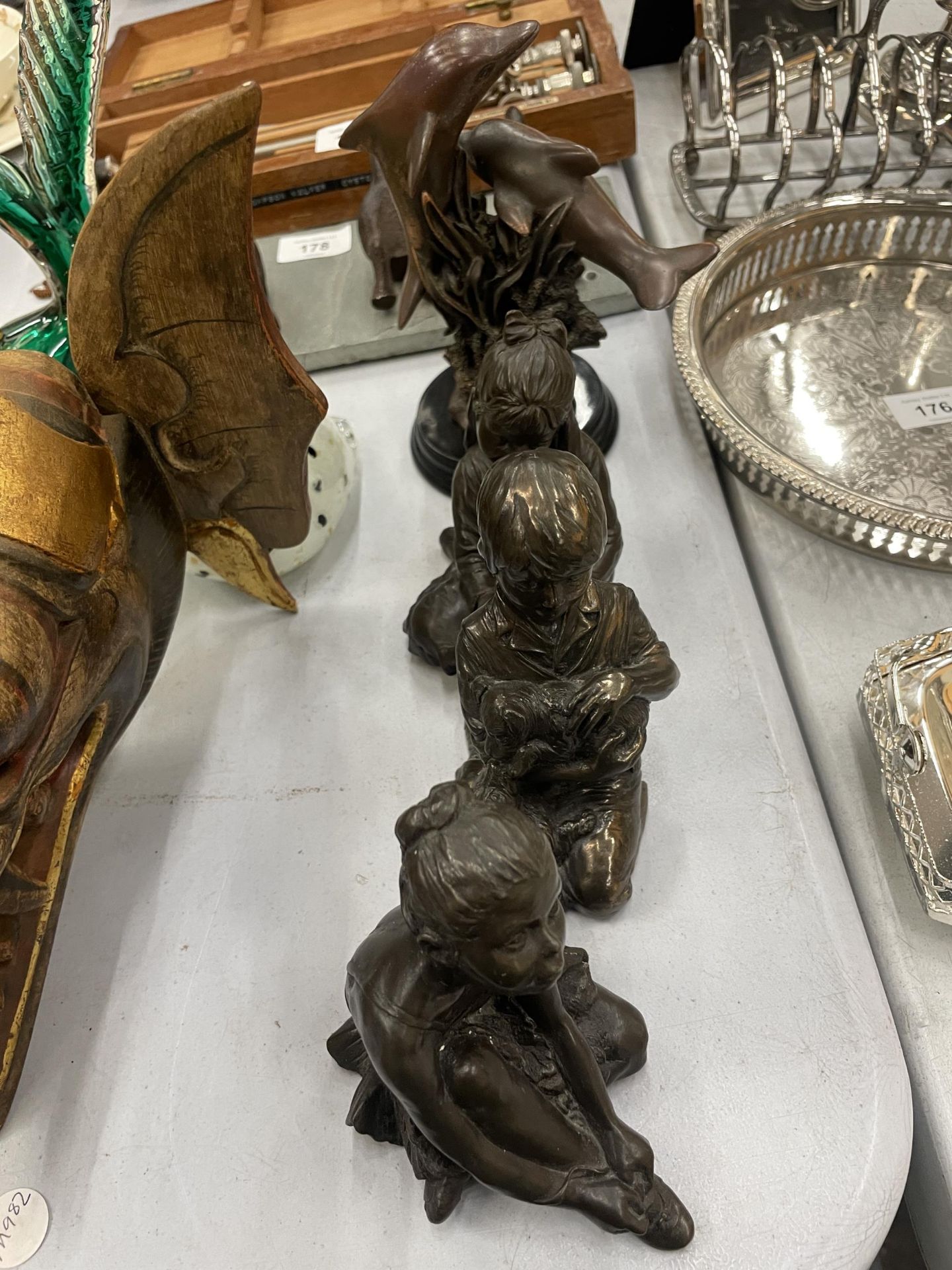 FOUR FIGURES TO INCLUDE A DOLPHIN AND THREE CHILDREN