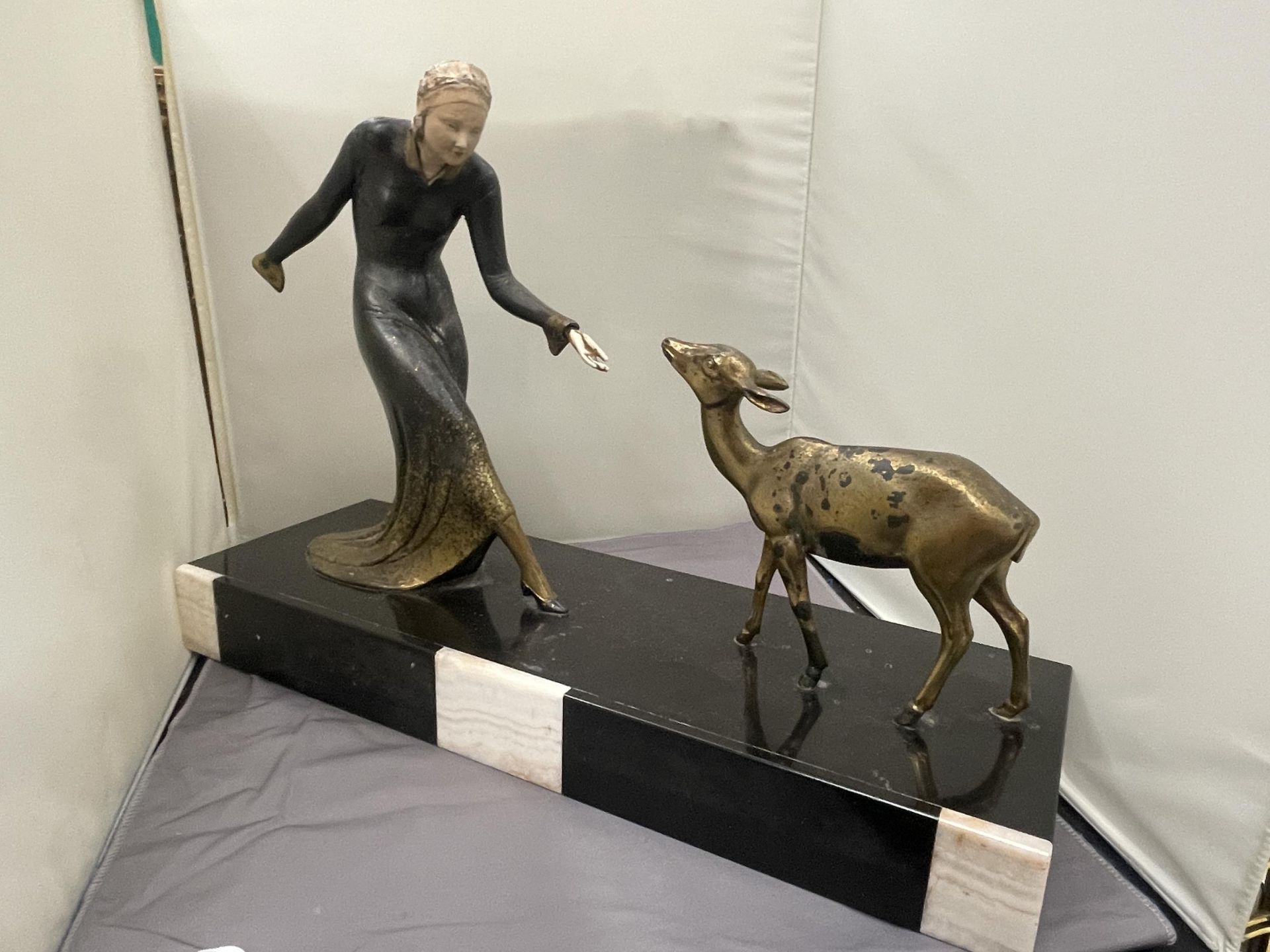 AN ART DECO STYLE BRASS FIGURE OF LADY FEEDING A FAWN. SET ON A BASE (LADIES HAND A/F)