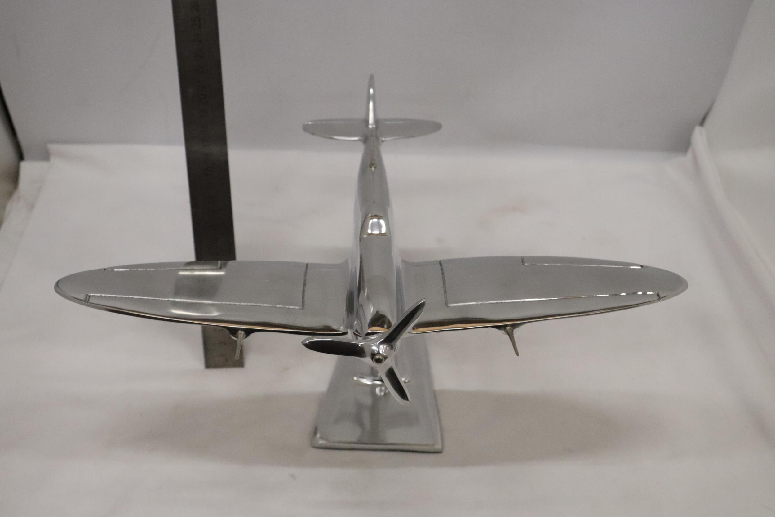 A LARGE CHROME SPITFIRE ON A STAND
