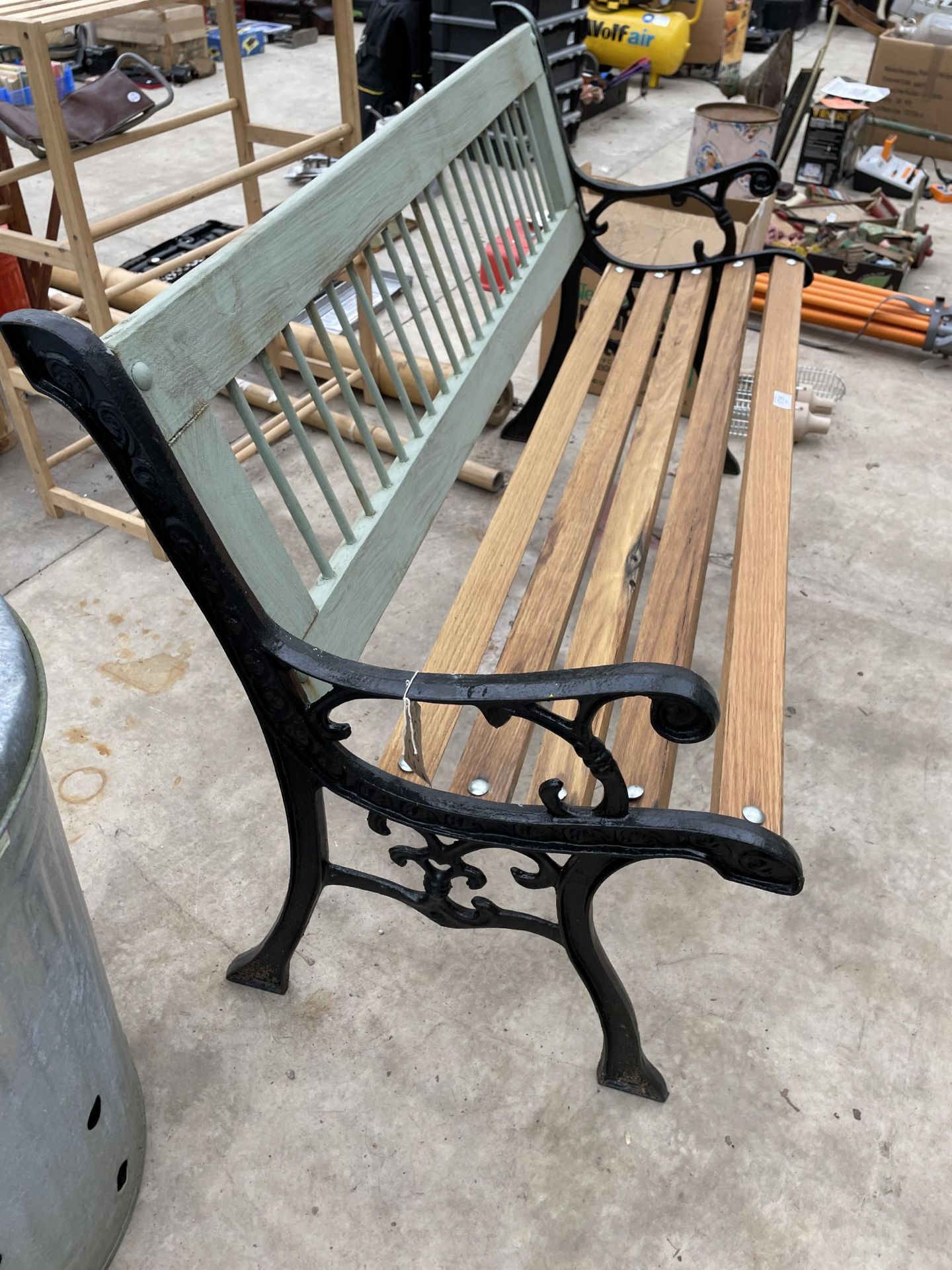 A WOODEN SLATTED GARDEN BENCH WITH DECORATIVE CAST BENCH ENDS - Image 2 of 2