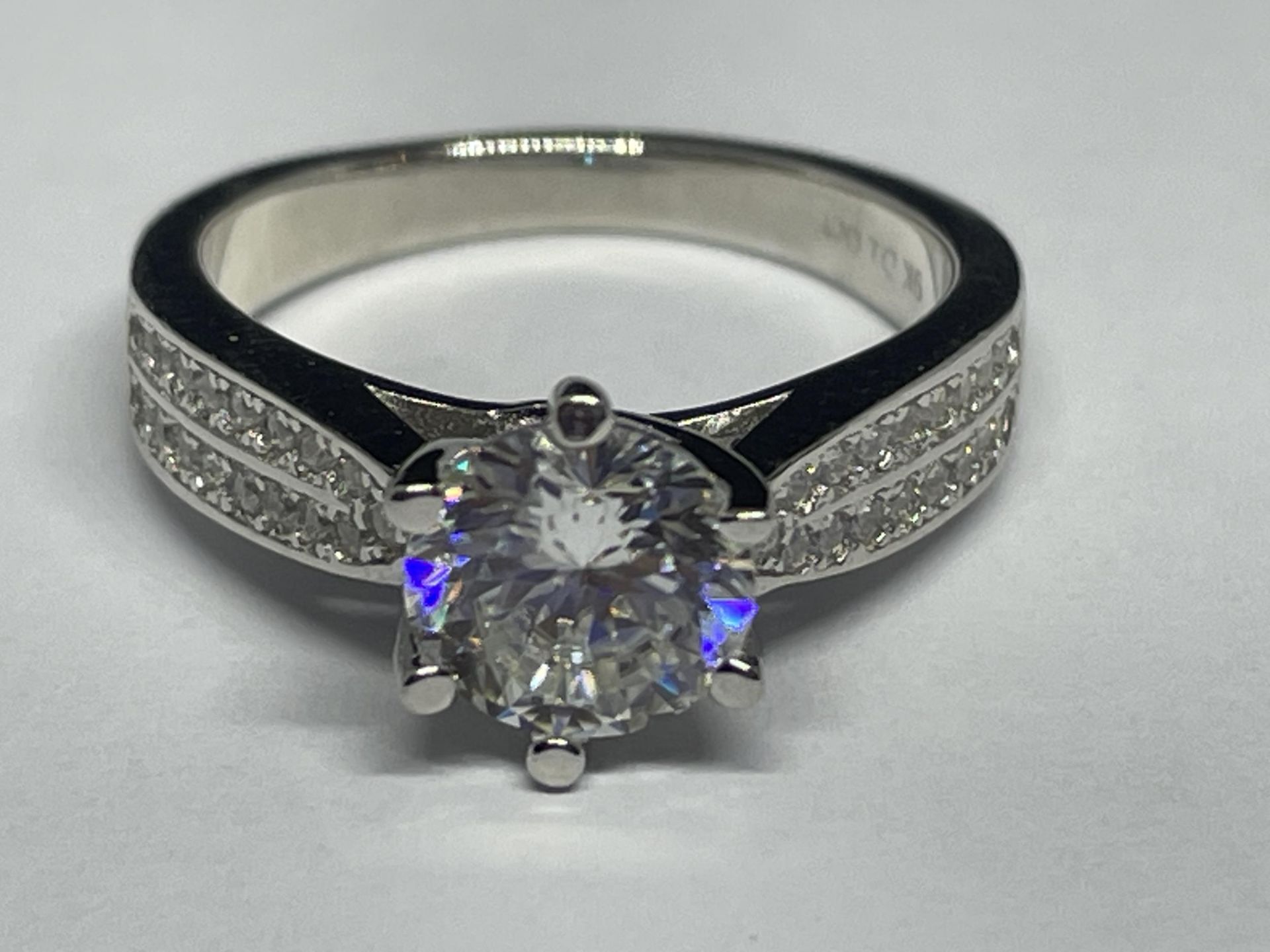 A MARKED 9K RING SET WITH A 1 CARAT OF MOISSANITE AS A SOLITAIRE AND CHIPS TO SHOULDERS SIZE H/I