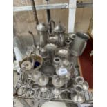 A LARGE ASSORTMENT OF SILVER PLATED ITEMS TO INCLUDE A TRAY, COFFEE POTS, CANDLE STICKS AND EGG CUPS