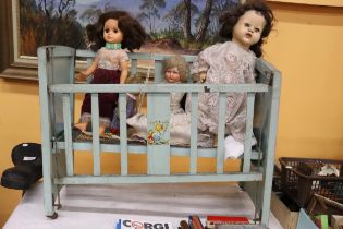 A VINTAGE DOLL'S COT WITH THREE DOLLS, ONE A PALITOY AND A TEDDY BEAR