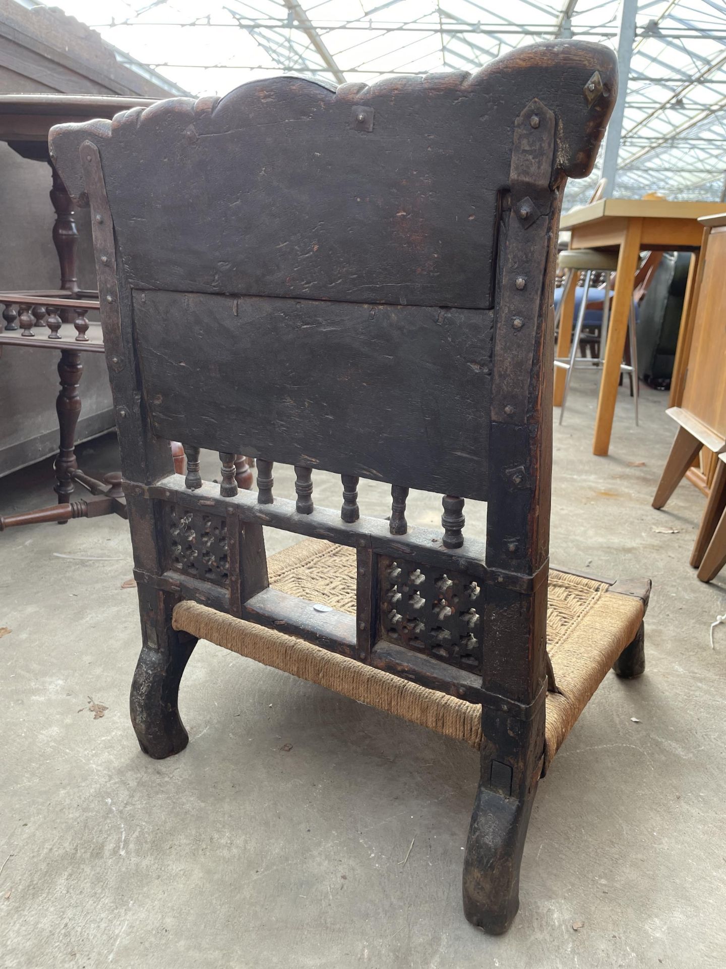 AN INDIAN TRIBAL LOW CHAIR WITH CARVED BACK AND WOVEN SEAT - Image 4 of 6