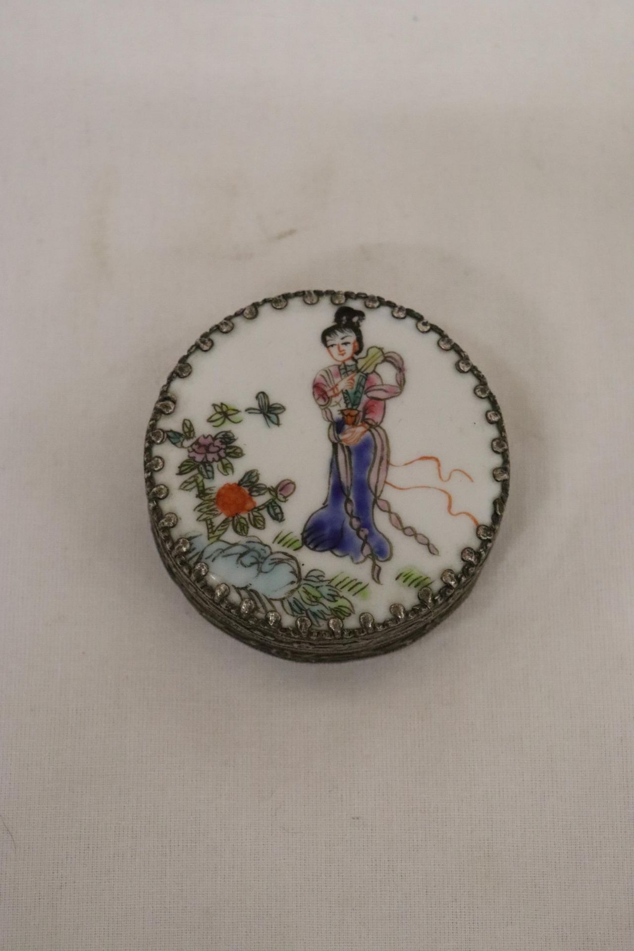 A VINTAGE SILVER TONE TRINKET BOX WITH THE IMAGE OF A JAPANESE LADY IN A FLORAL GARDEN