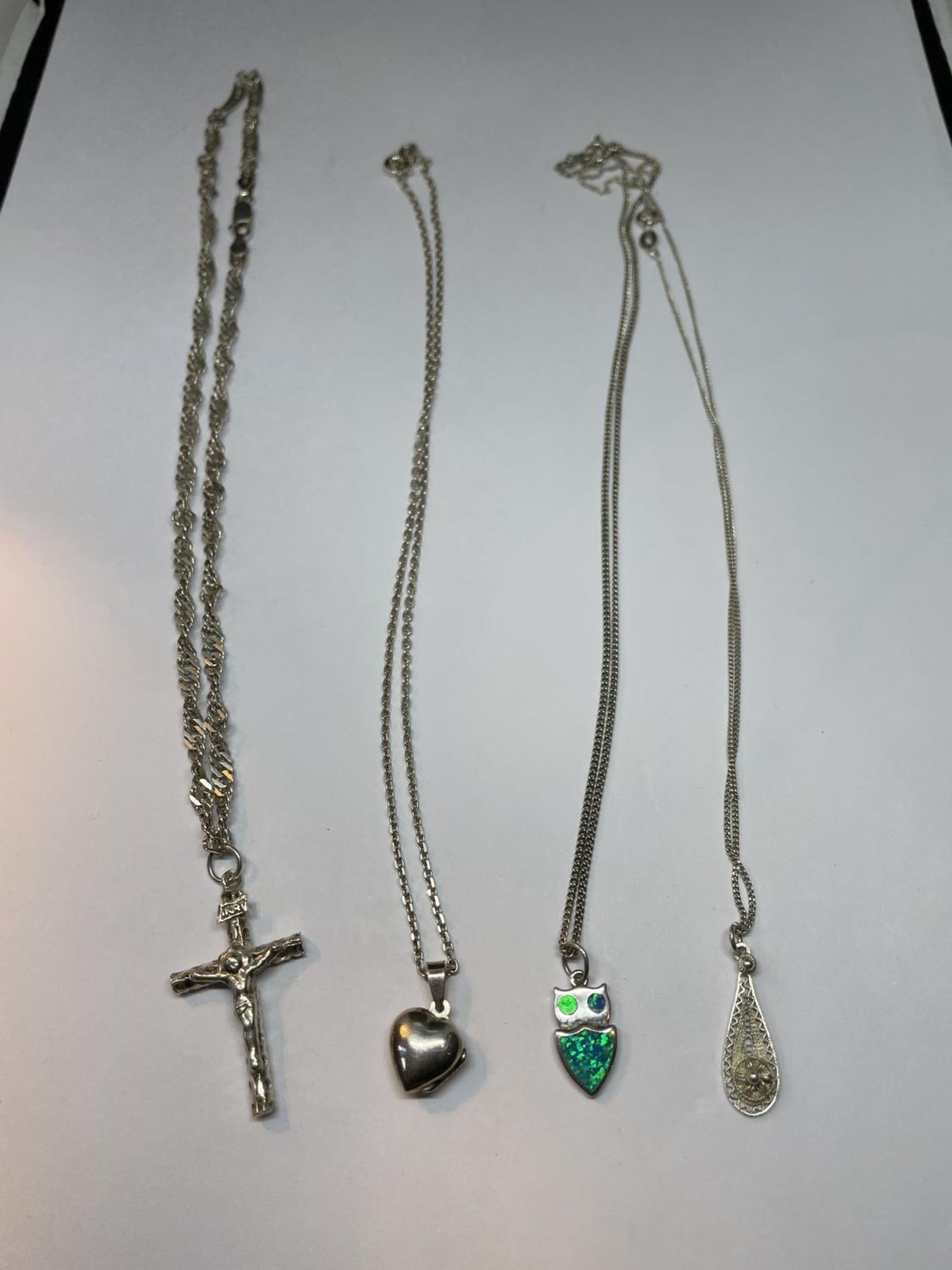 FOUR SILVER NECKLACES WITH PENDANTS