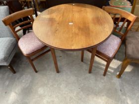A MID 20TH CENTURY OAK TABLE 34" DIAMETER AND A PAIR OF 1950'S KITCHEN CHAIRS