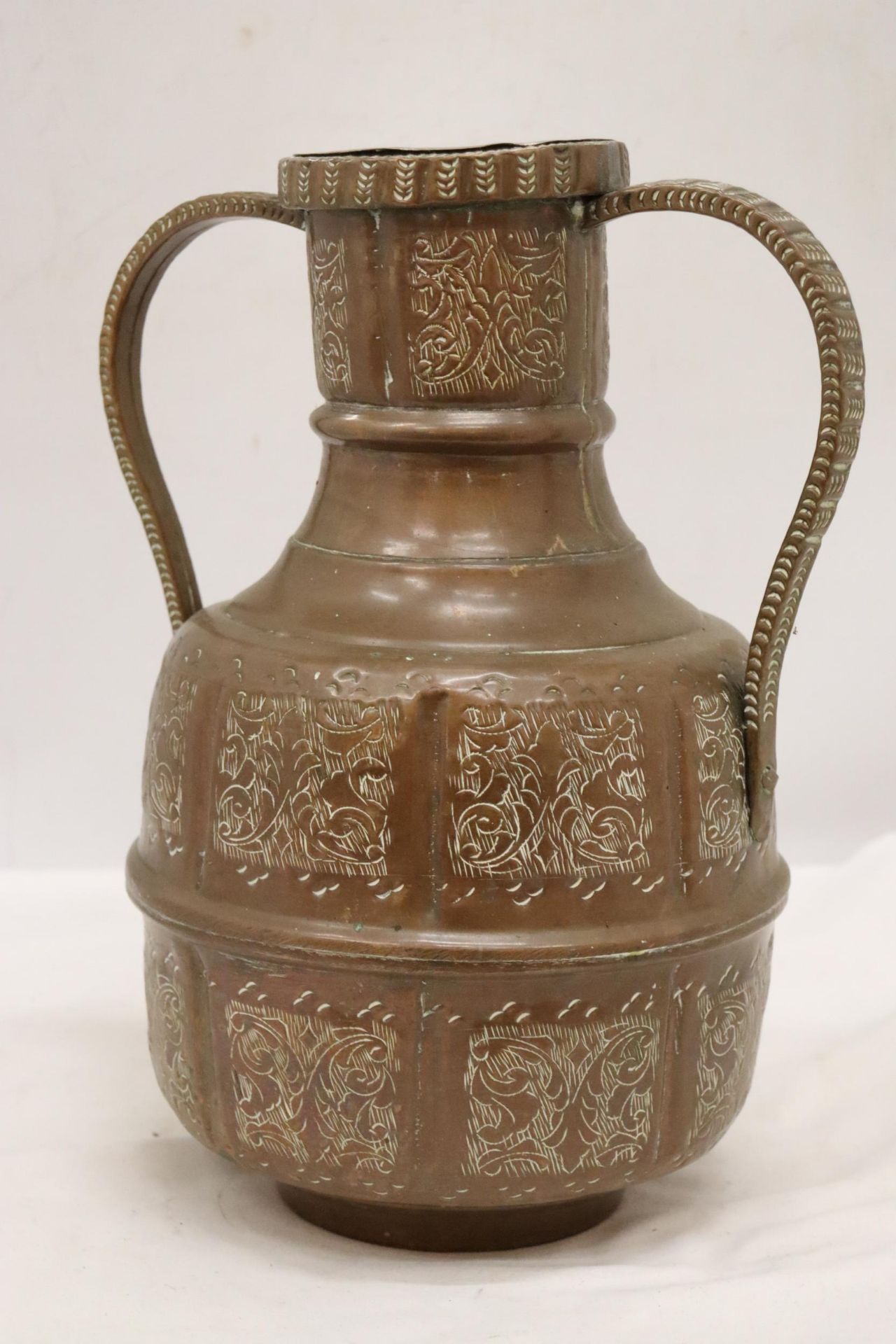 A SIGNED TWIN HANDLED EASTERN COPPER POT