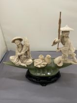 AN ORIENTAL CARVING OF FISHERMEN ON A POSSIBLY JADE BOAT, HEIGHT 20CM, WIDTH 27CM