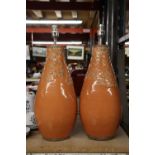 A LARGE PAIR OF STUDIO POTTERY LAMP BASES IN ORANGE WITH EMBOSSED LEAF DESIGN, HEIGHT APPROX 40CM