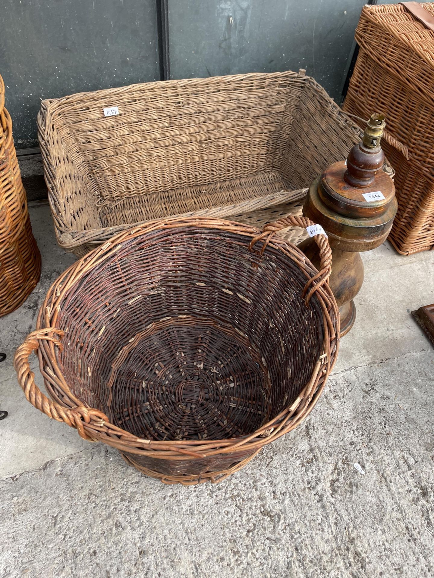 TWO LARGE WICKER LOG BASKETS AND A DECORATIVE WOODEN TABLE LAMP