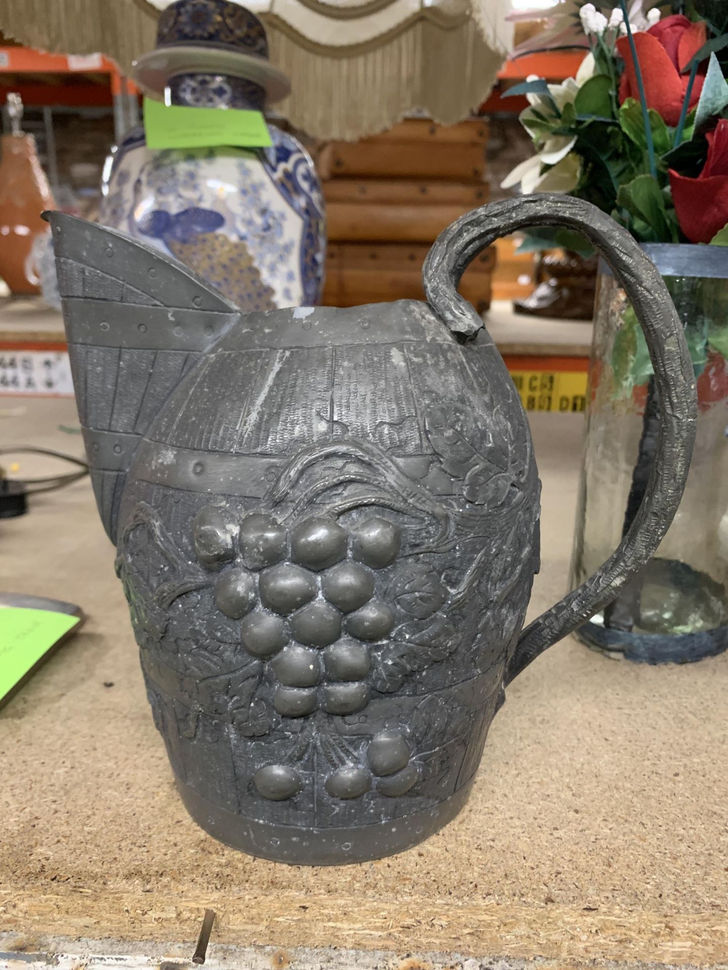 A VINTAGE PEWTER WINE JUG IN THE FORM OF A BARREL WITH GRAPE AND VINE DECORATION, HEIGHT 19CM