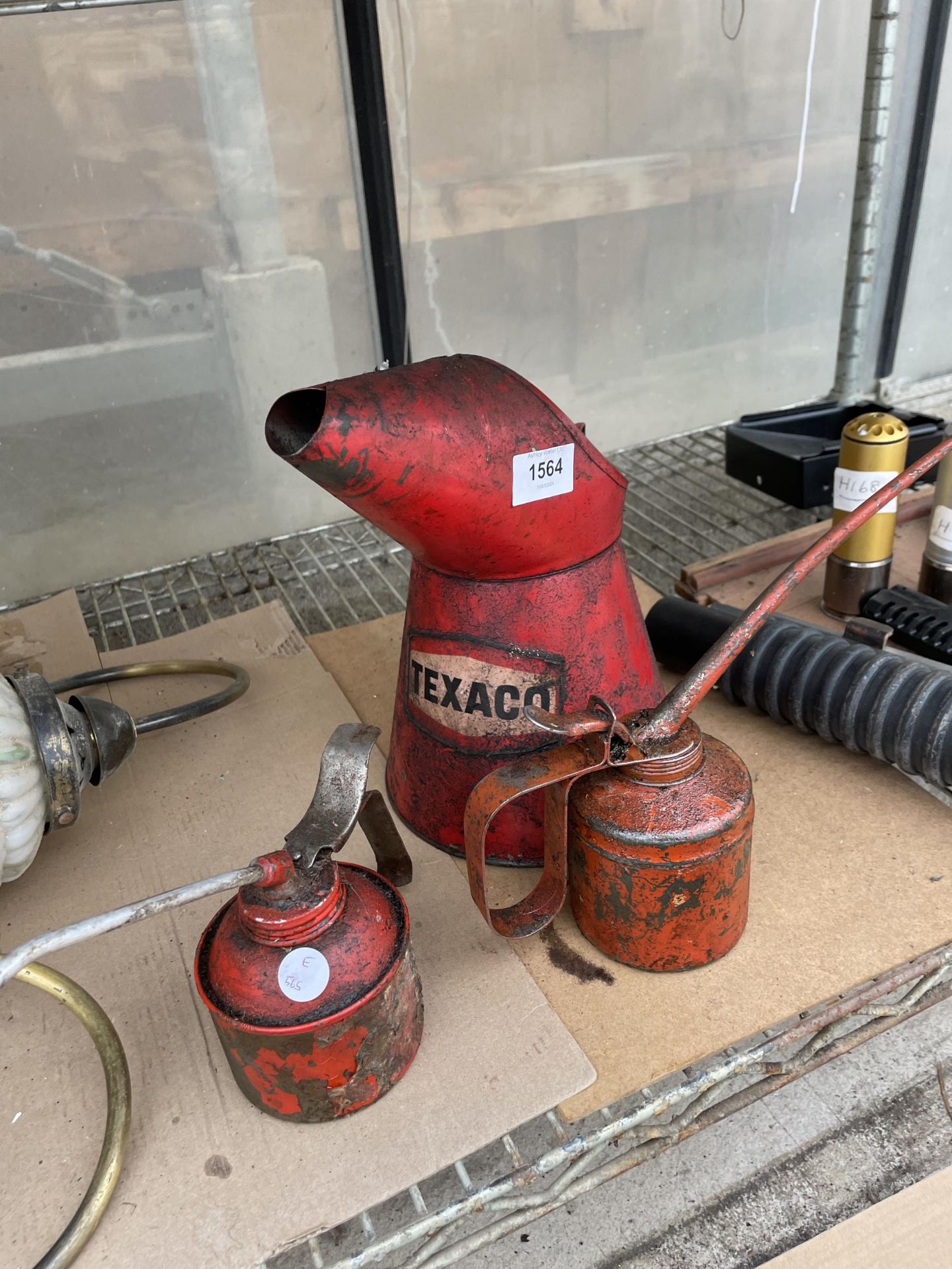 A VINTAGE TEXACO OIL JUG AND TWO PUMP ACTION OIL CANS
