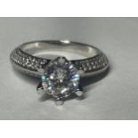 A MARKED 9K RING SET WITH A 1 CARAT MOISSANITE AND SMALLER ONES TO THE SHOULDERS SIZE H/I