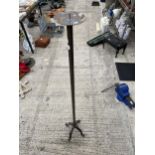 A TALL WROUGHT IRON CANDLE STICK