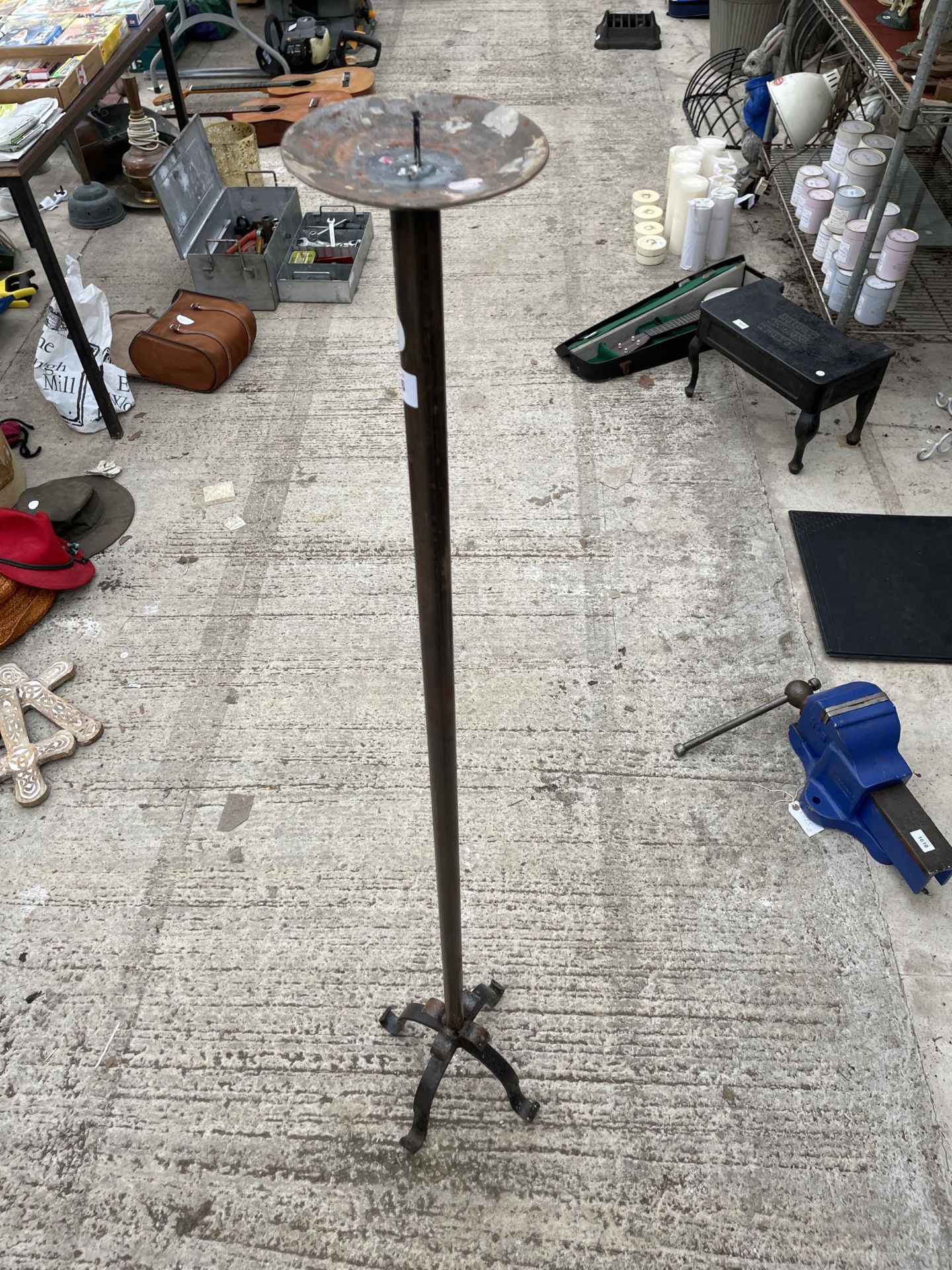 A TALL WROUGHT IRON CANDLE STICK