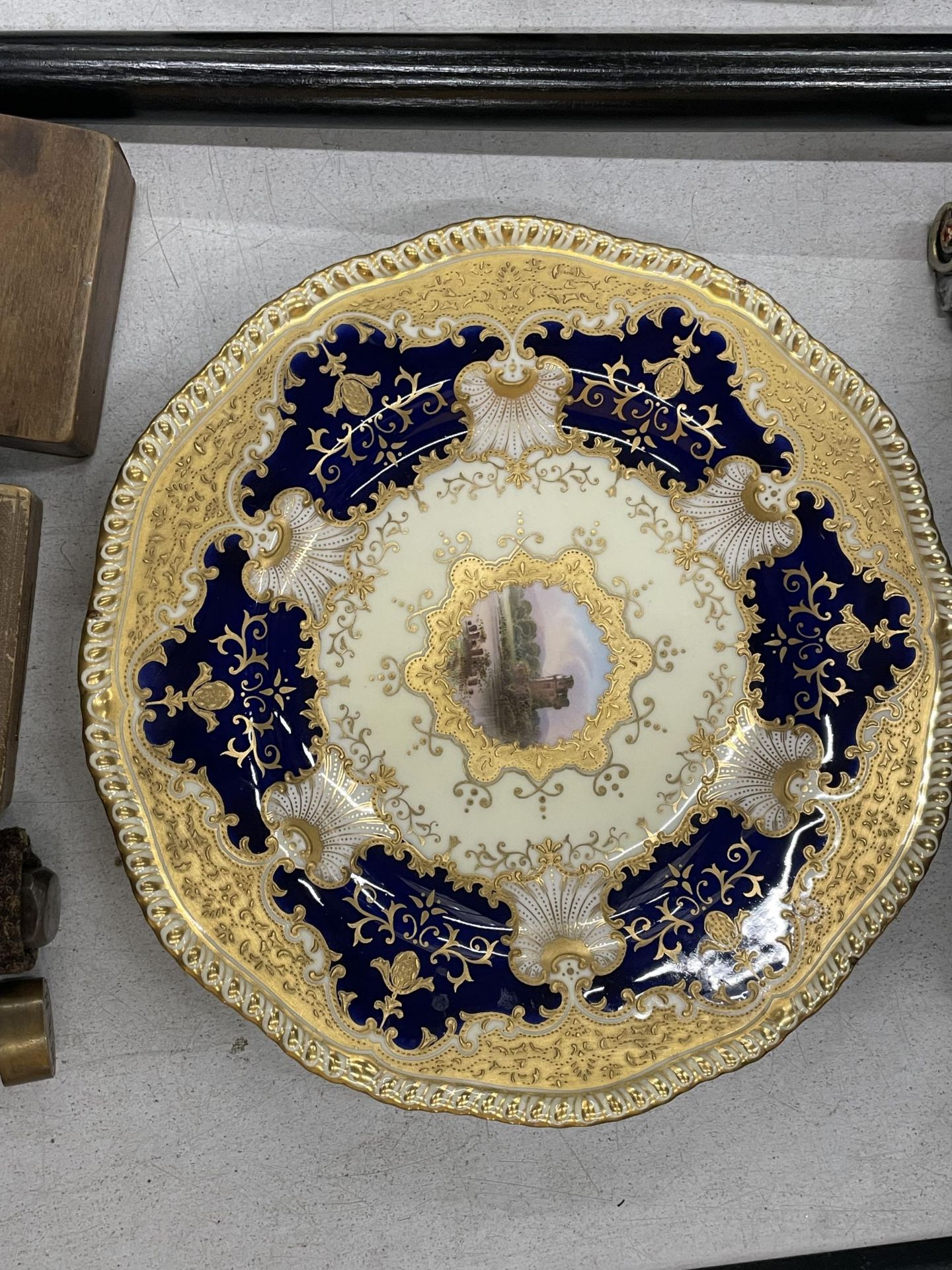 A COALPORT GILT AND BLUE CABINET PLATE WITH CENTRE PAINTING OF A CASTLE