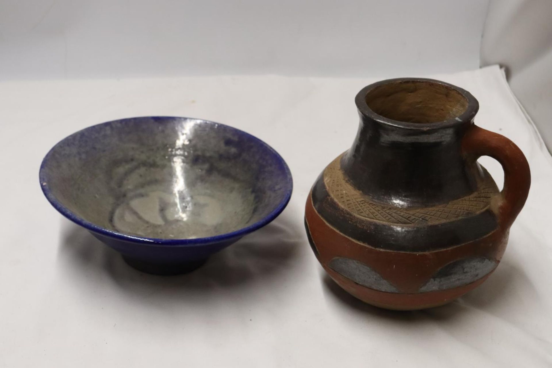 A BLUE AND PEARLESCENT STUDIO POTTERY STYLE BOWL TOGETHER WITH A STONEWARE JUG