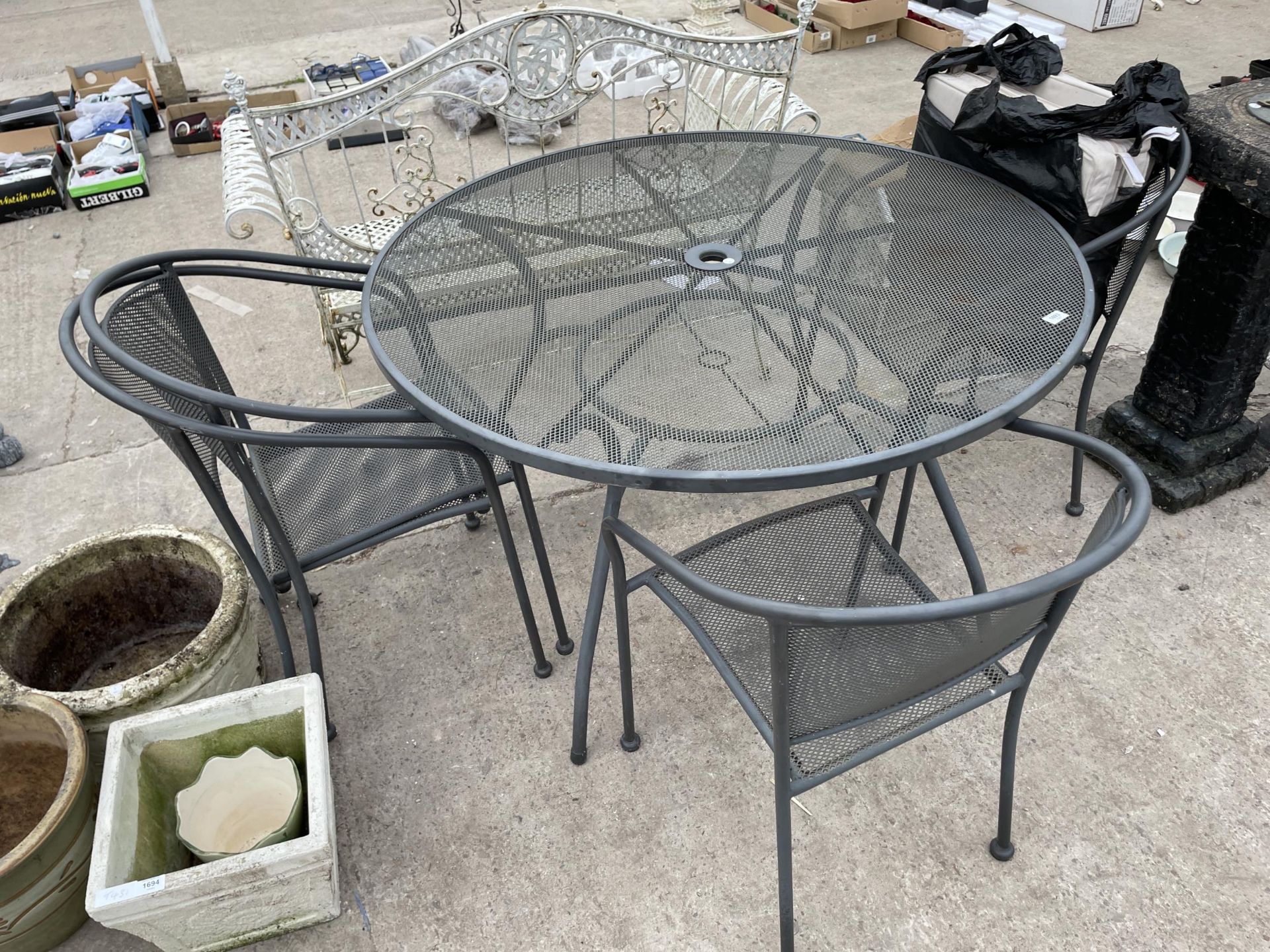 A METAL PATIO FURNITURE SET COMPRISING OF A ROUND TABLE AND FOUR CHAIRS WITH CUSHIONS