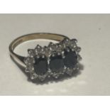 A 9 CARAT GOLD RING WITH THREE LARGE IN LINE SAPPHIRES SURROUNDED BY CUBIC ZIRCONIAS SIZE L/M