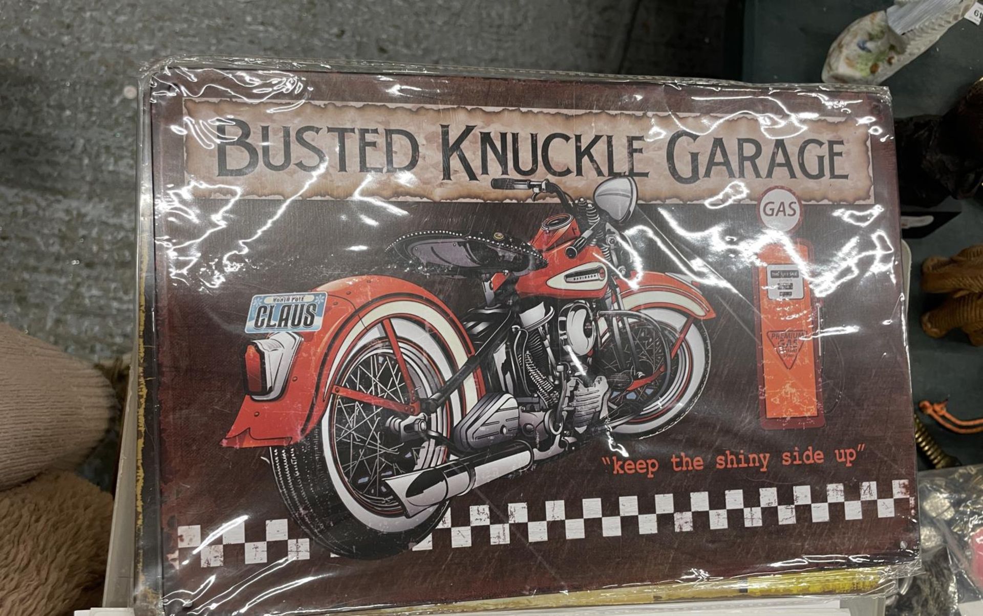 A TIN BUSTED KNUCKLE GARAGE SIGN