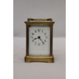 A VINTAGE BRASS CARRIAGE CLOCK WITH BEVELED GLASS SECTIONS TO REVEAL UPPER ESCAPEMENT AND INNER