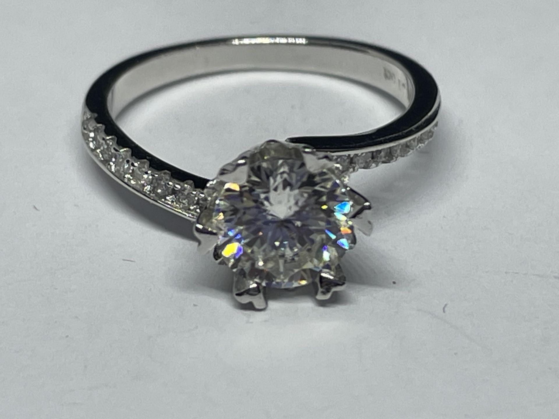 A MARKED 9K RING SET WITH A 1 CARAT OF MOISSANITE AS A SOLITAIRE AND CHIPS TO SHOULDERS SIZE I