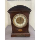 A MAHOGANY INLAID MANTLE CLOCK WITH INSCRIPTION PLATE (A/F LEG MISSING)