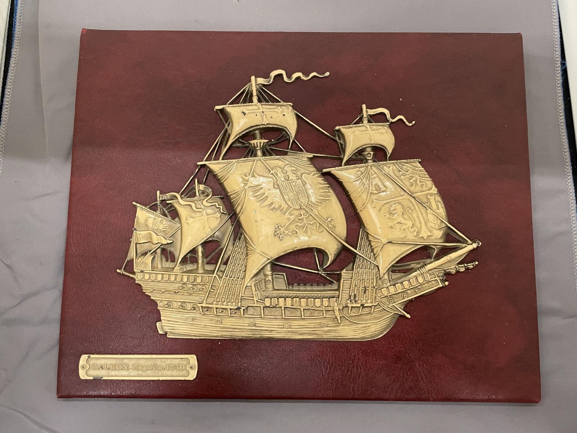 A VINTAGE EMBOSSED SPANISH GALLEON ON RED MOROCCO LEATHER, 30CM X 24CM