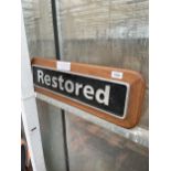 A METAL 'RESTORED' SIGN WITH WOODEN PLINTH BACKING