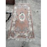 A PEACH PATTERNED FRINGED RUG